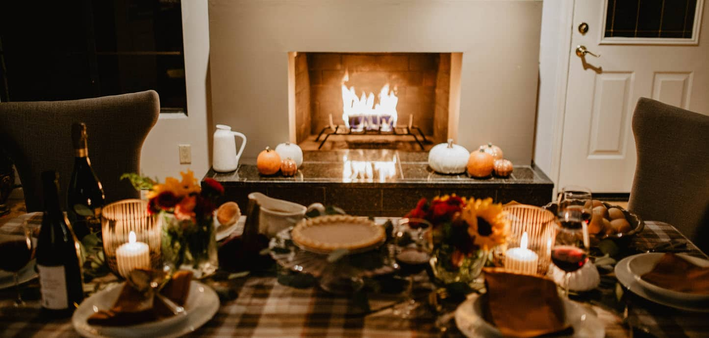 An inviting Thanksgiving scene with a cozy fireplace with a duraflame firelog burning, a festive table setting, and seasonal decor. This image captures the warmth of a holiday gathering.