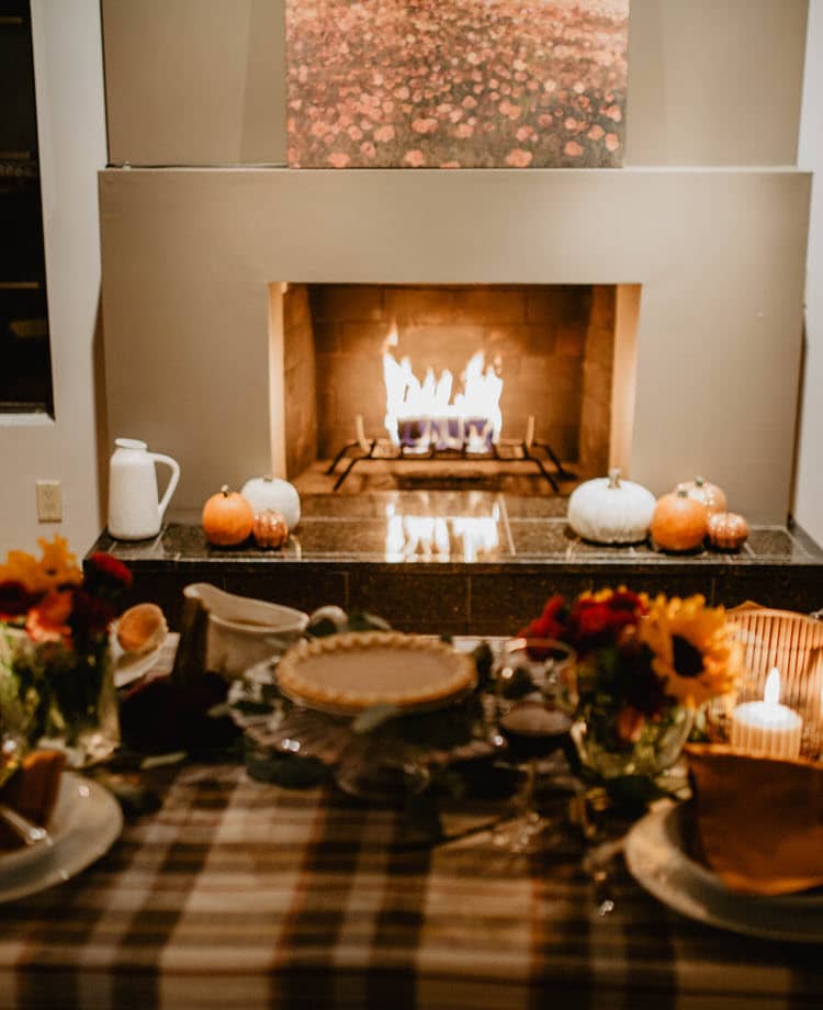 An inviting Thanksgiving scene with a cozy fireplace with a duraflame firelog burning, a festive table setting, and seasonal decor. This image captures the warmth of a holiday gathering.